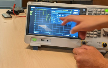 An instructor demonstrating for the class using an oscilloscope