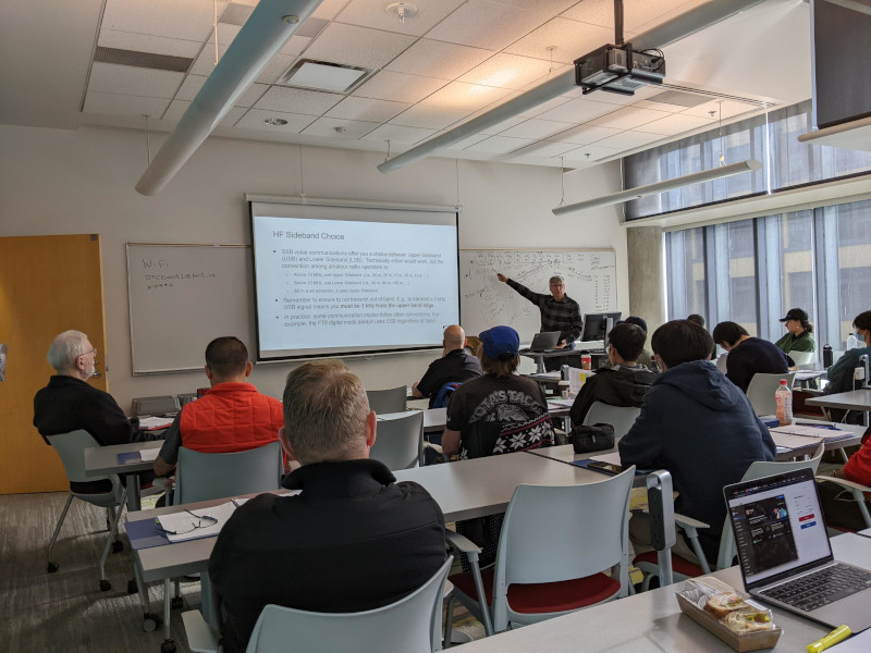 A VECTOR instructor pointing to notes on a screen at the front of a class full of students